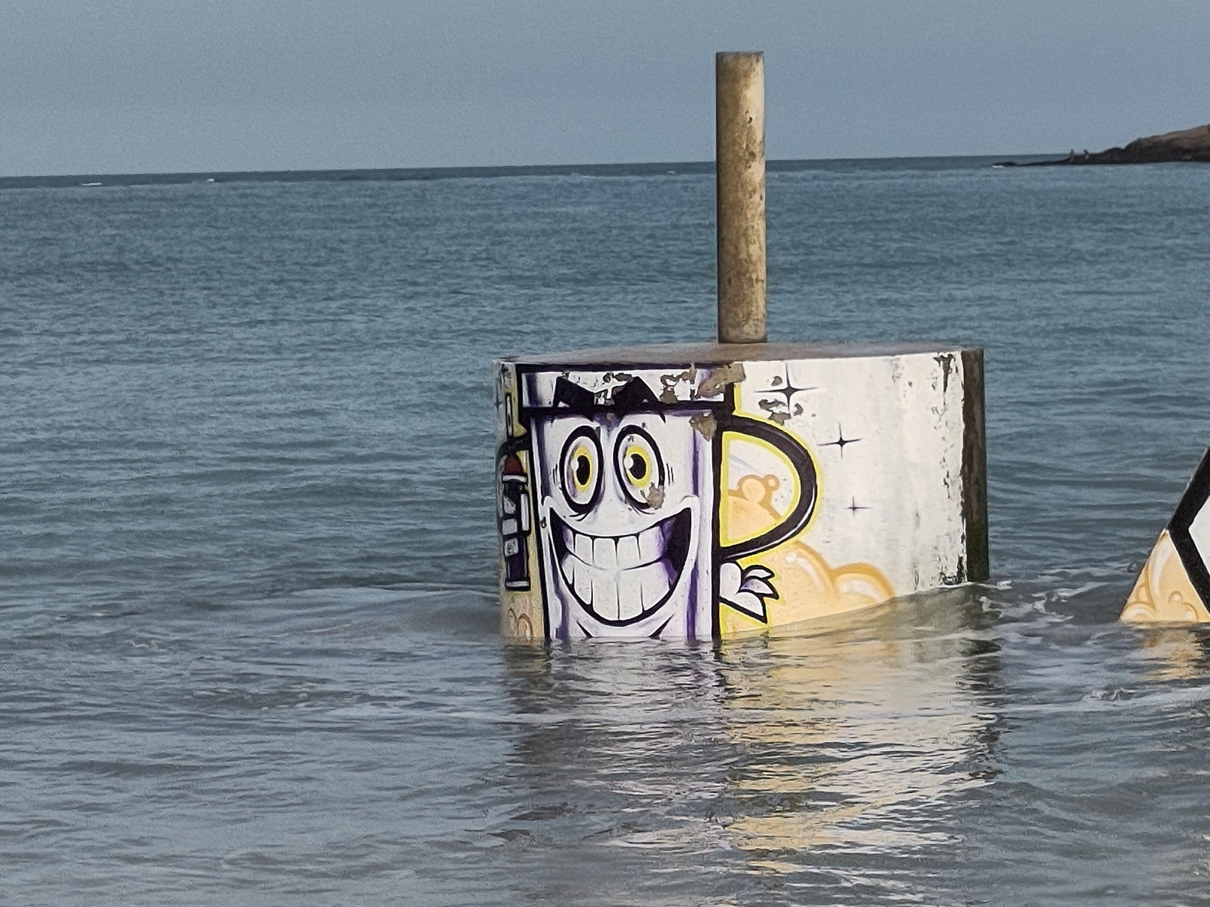 Carton coffee mug in pier pillar in water.